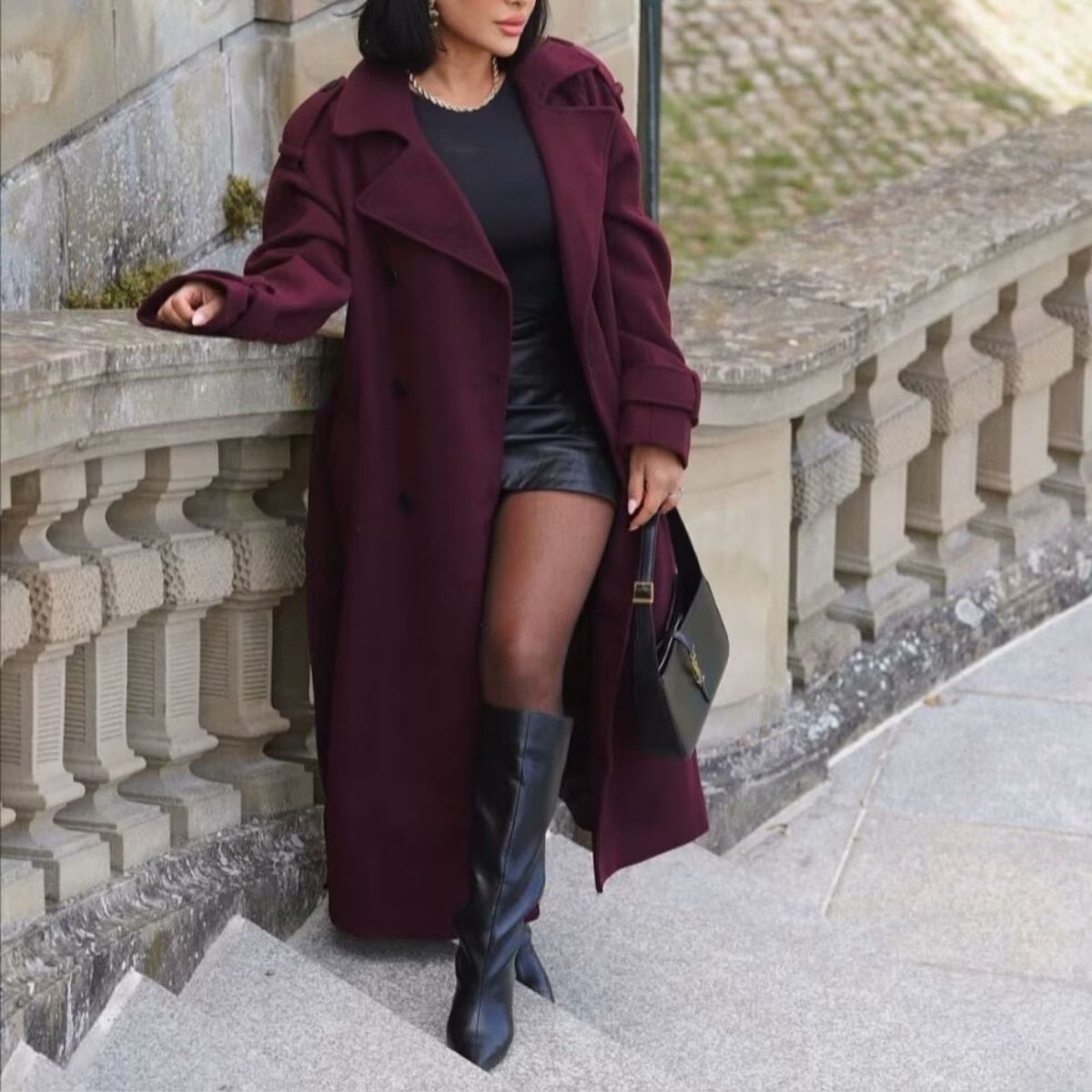 Burgundy long belted trench coat with notched lapels and button details