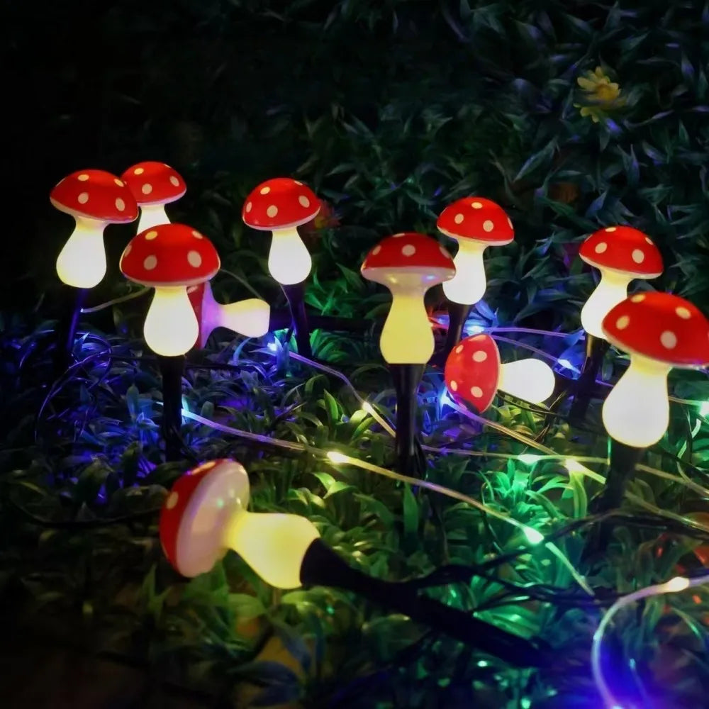 Solar mushroom garden lights with red caps and warm yellow glowing bulbs on ground stakes
