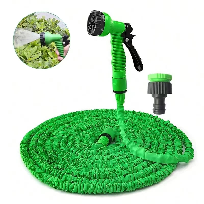 Expandable garden hose with green spray nozzle and coiled green hose on a base