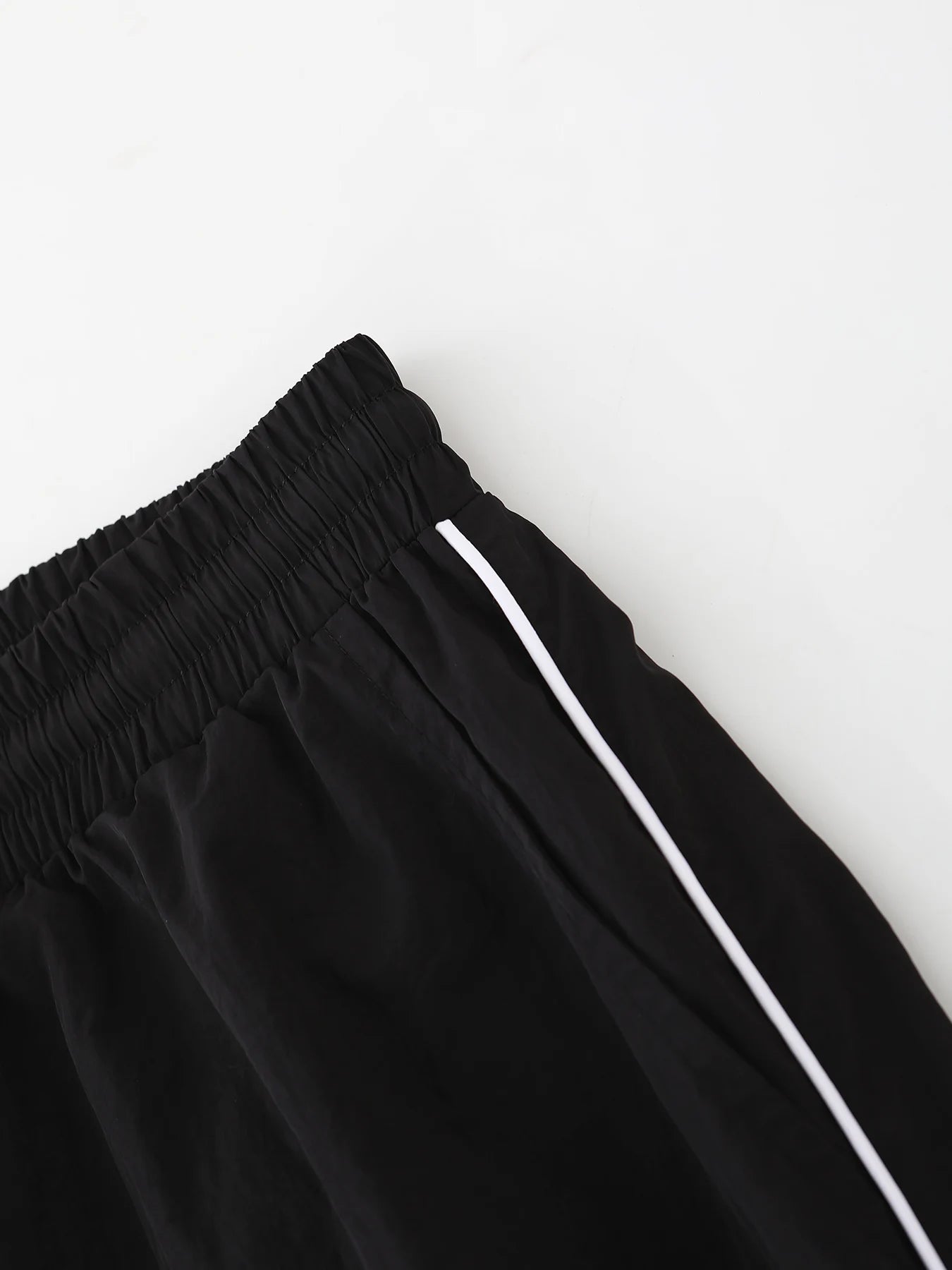Black wide-leg trousers with elastic waistband and white drawstring cord