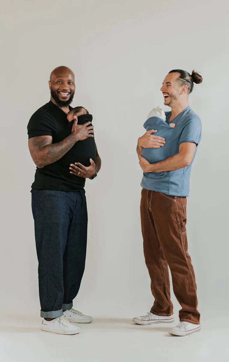 Baby carrier sling T-shirts in black and blue-gray on two men, each holding a baby.