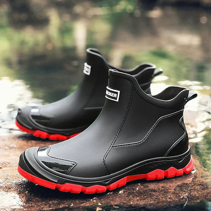 Men's waterproof black ankle boots with side stitch, pull tabs, and red rugged outsole