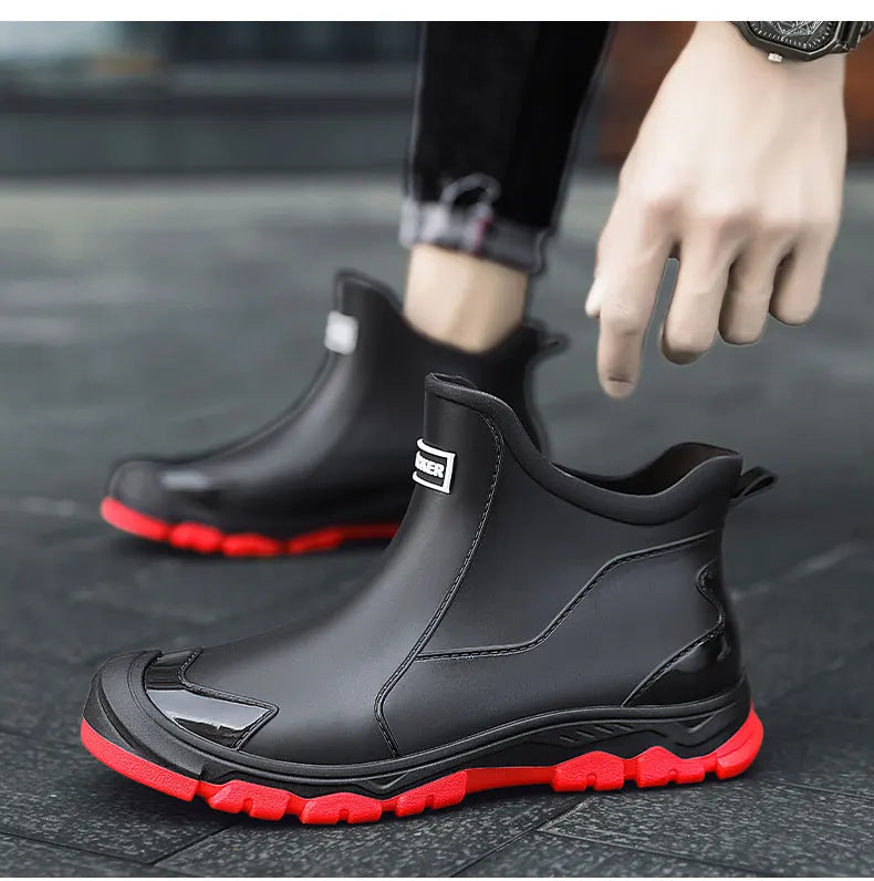 Men's waterproof black ankle boots with red outsole and pull tabs; low-cut profile