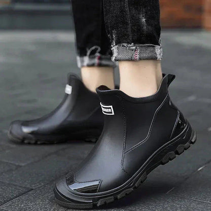 Men's waterproof black ankle boots with red outsole, side stitch, and pull tabs