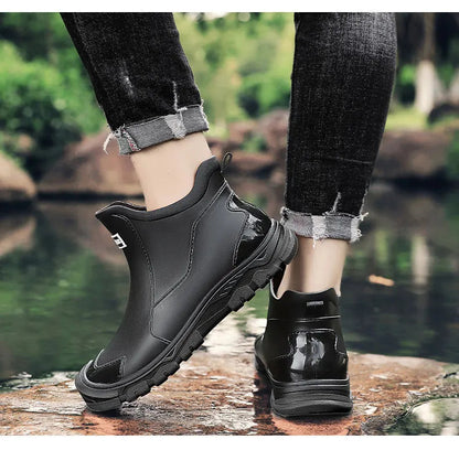 Men's waterproof black ankle boots with red tread sole and rear heel detail