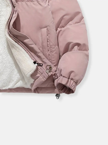 Women’s zip-up winter jacket close-up of zipper and front panel, pink