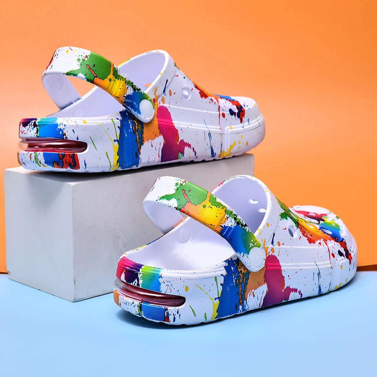 Ivory air-cushion clogs with colorful paint-splatter print, molded heel strap, thick sole