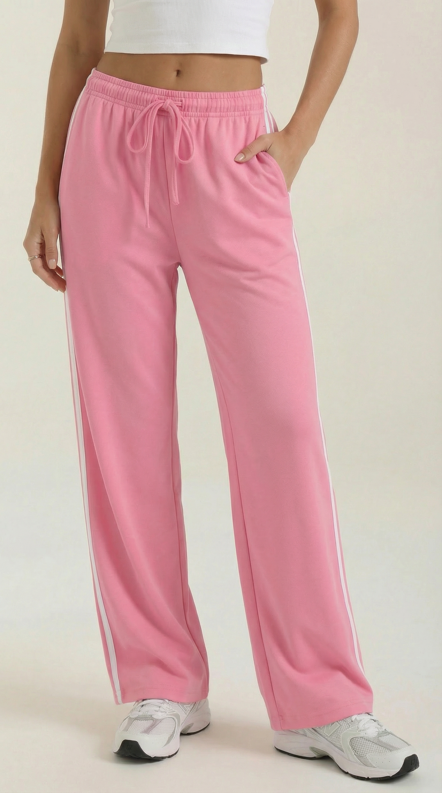 Pink wide-leg track pants with elastic waistband, drawstring tie, and white side stripes
