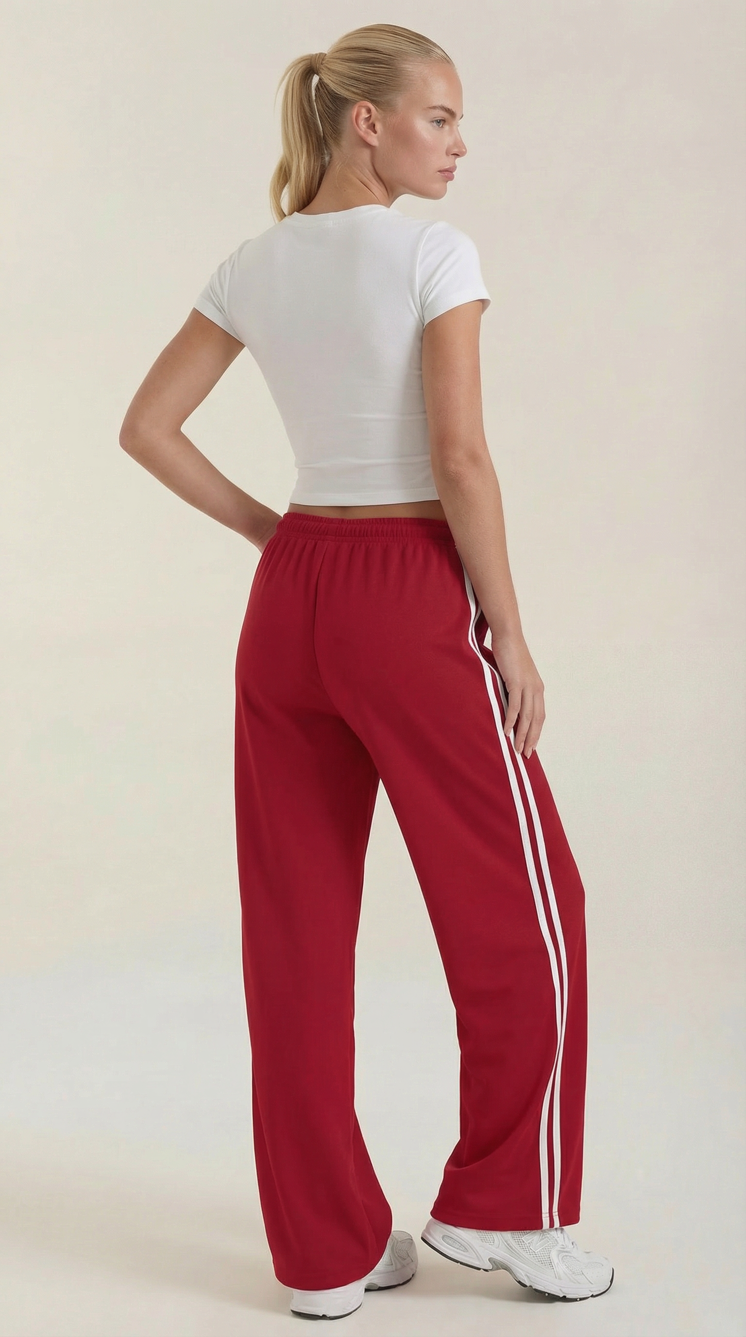 Red wide-leg track pants with elastic waistband, drawstring tie, and white side stripes