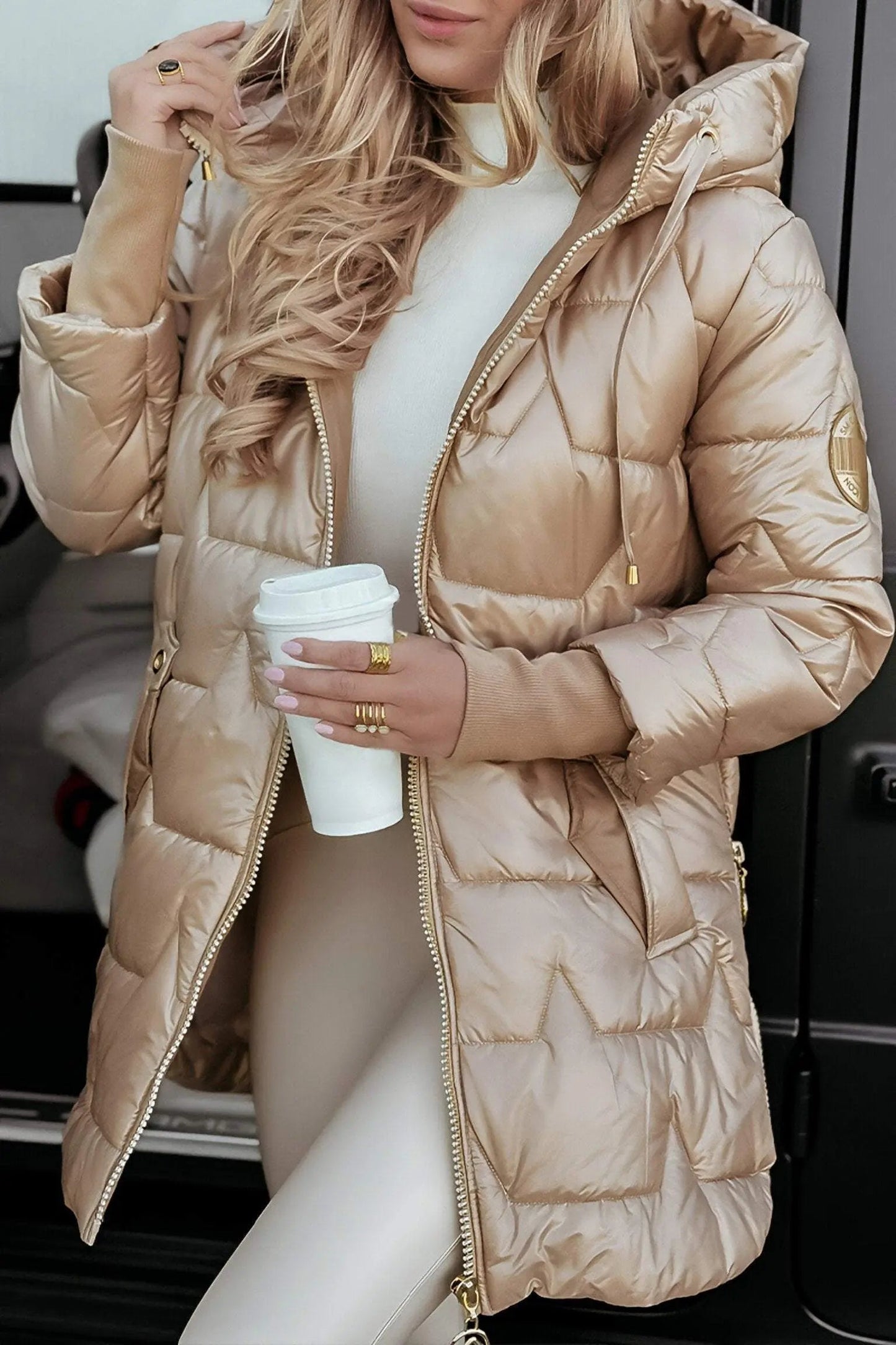 Beige hooded puffer jacket with full zip, quilted panels, and adjustable hood.