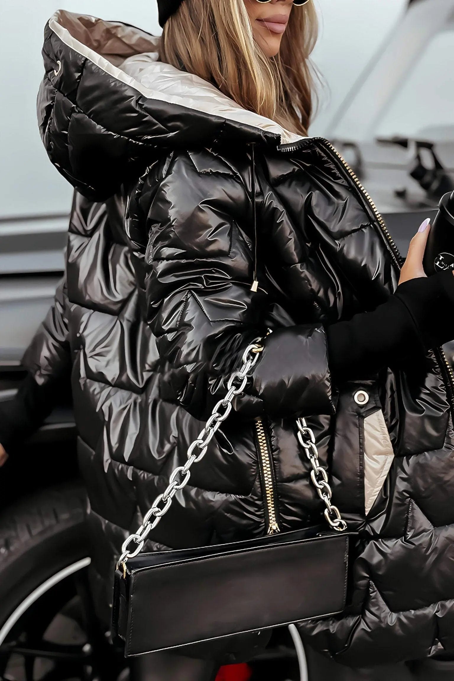 Black hooded puffer jacket with full zip, quilted shoulders, and long sleeves.