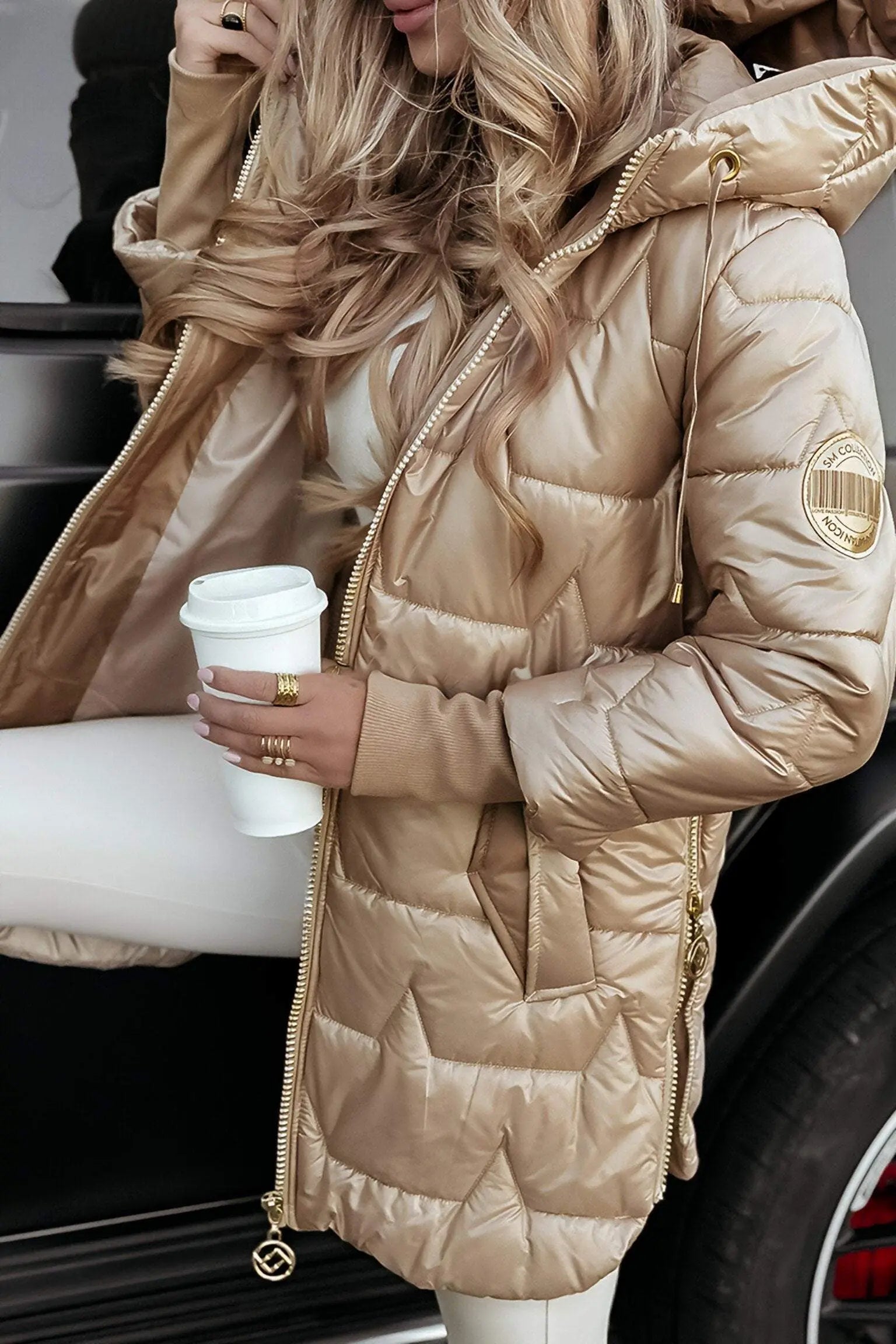 Tan hooded puffer jacket with full zip, quilted panels, and adjustable hood.