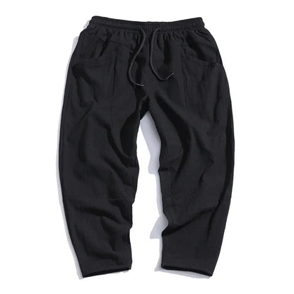 Black cropped drawstring pants with elastic waistband, relaxed tapered legs