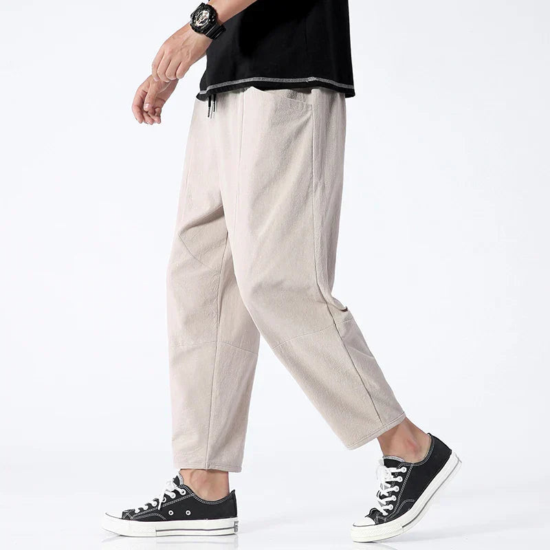 Beige cropped drawstring pants with elastic waistband, relaxed tapered fit
