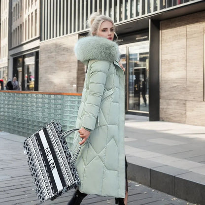 Mint green long down coat with quilted panels and light fur-trimmed hood