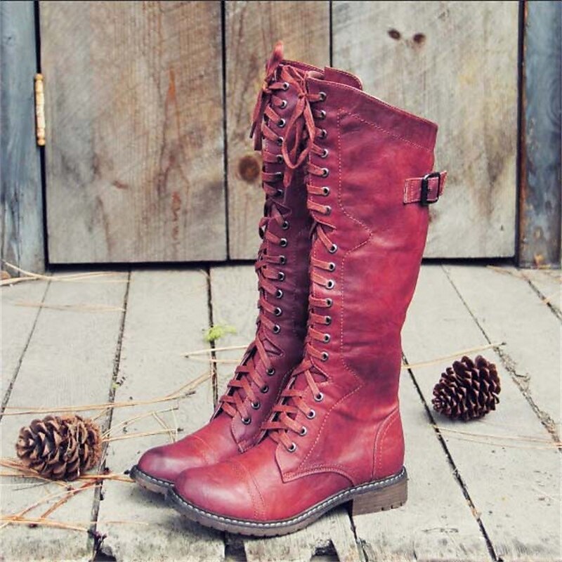 Red high lace-up riding boots with buckle strap and stitched detailing.