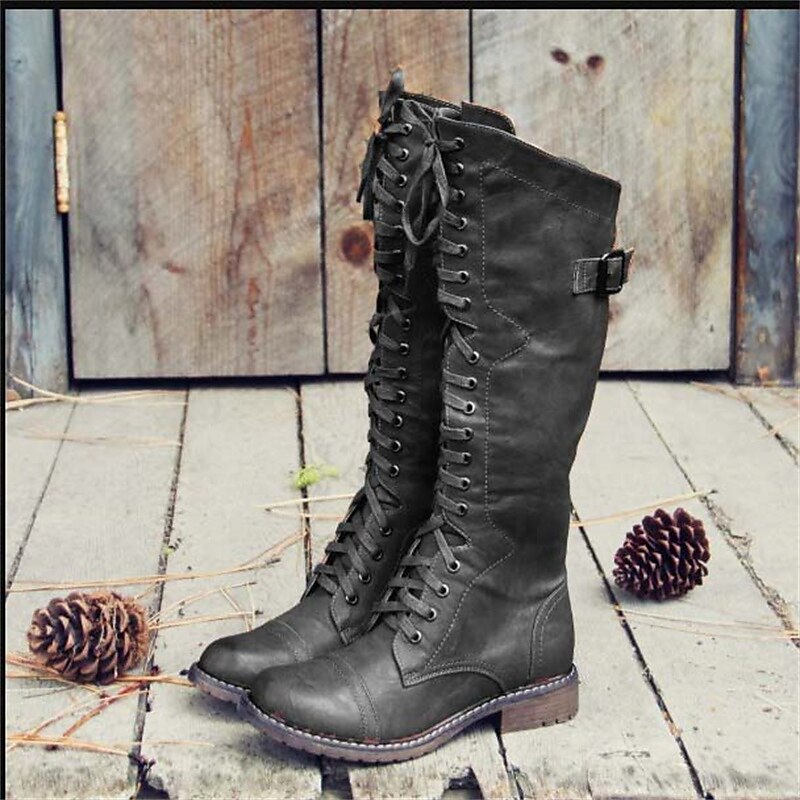 Black high lace-up riding boots with buckle strap and rugged sole.