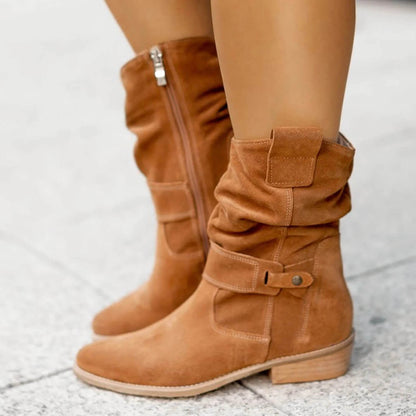 Tan suede slouch boots with front buckle strap, side zipper, and stacked heel