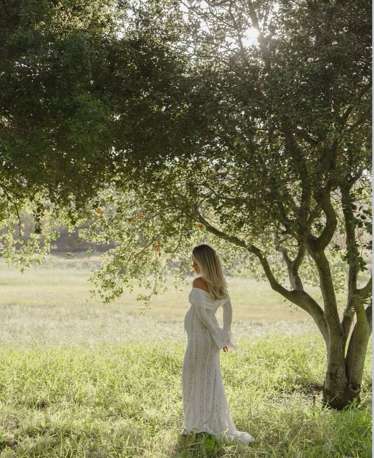 White lace off-shoulder maternity dress with long sleeves and flowing skirt, back/side view