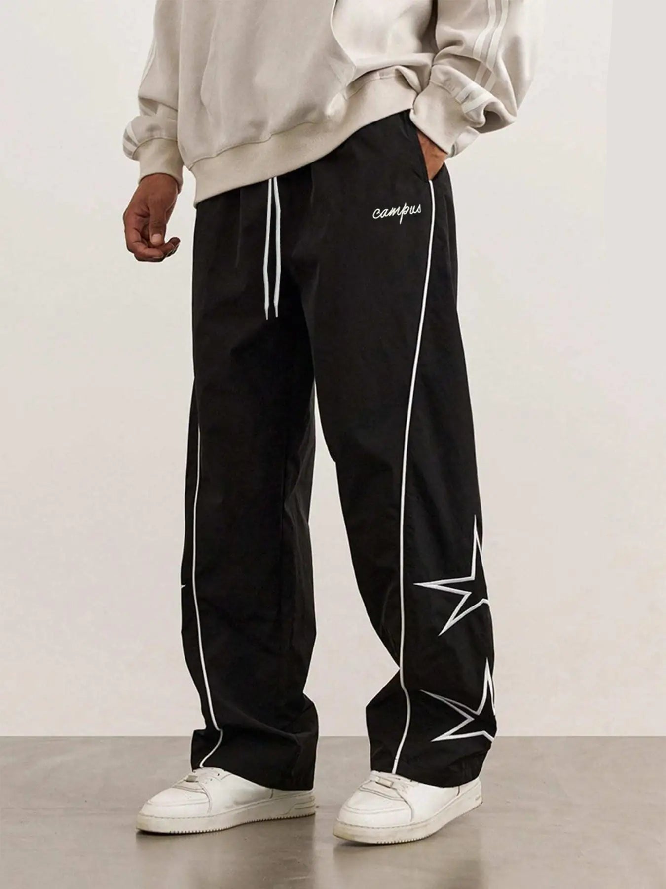 Black quick-dry trousers with white side stripe, star print, elastic drawstring waist.