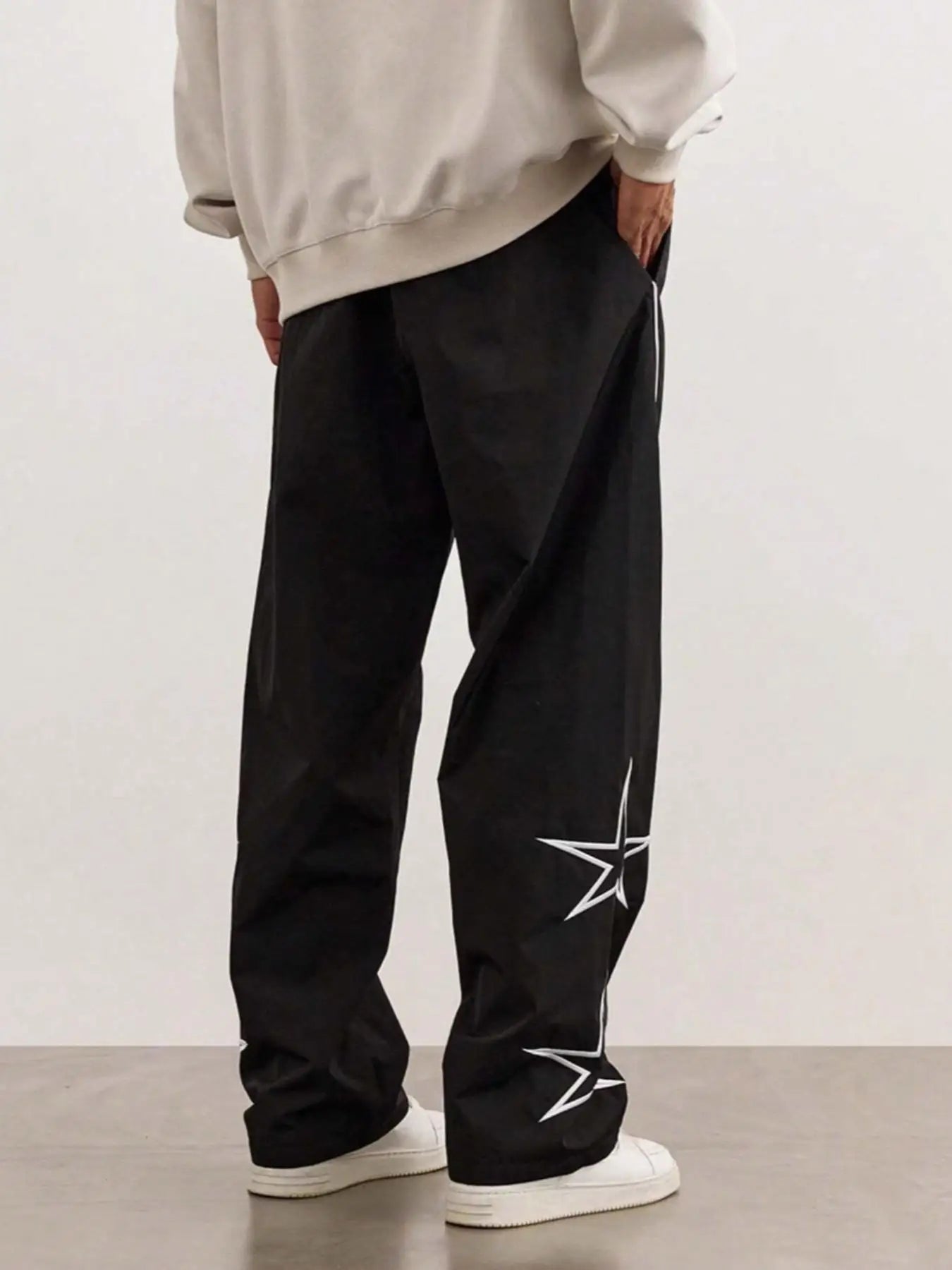 Black quick-dry trousers with white stripe and star graphics along the leg.