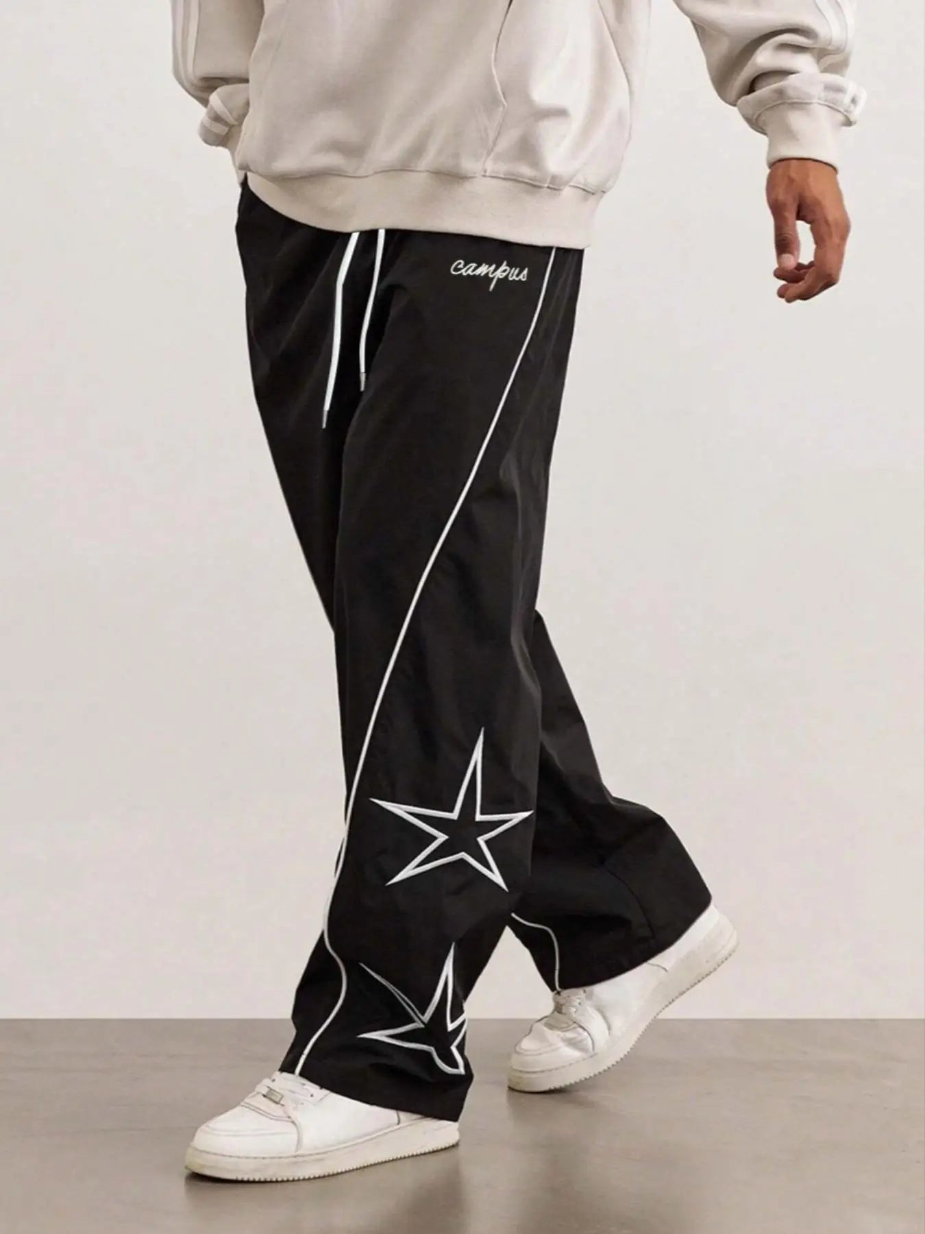 Black quick-dry trousers with white diagonal stripe and star patch on the thigh.