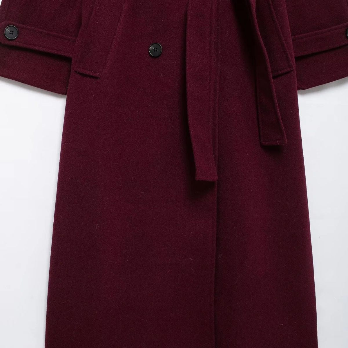 Burgundy belted trench coat close-up with buttoned flap pockets