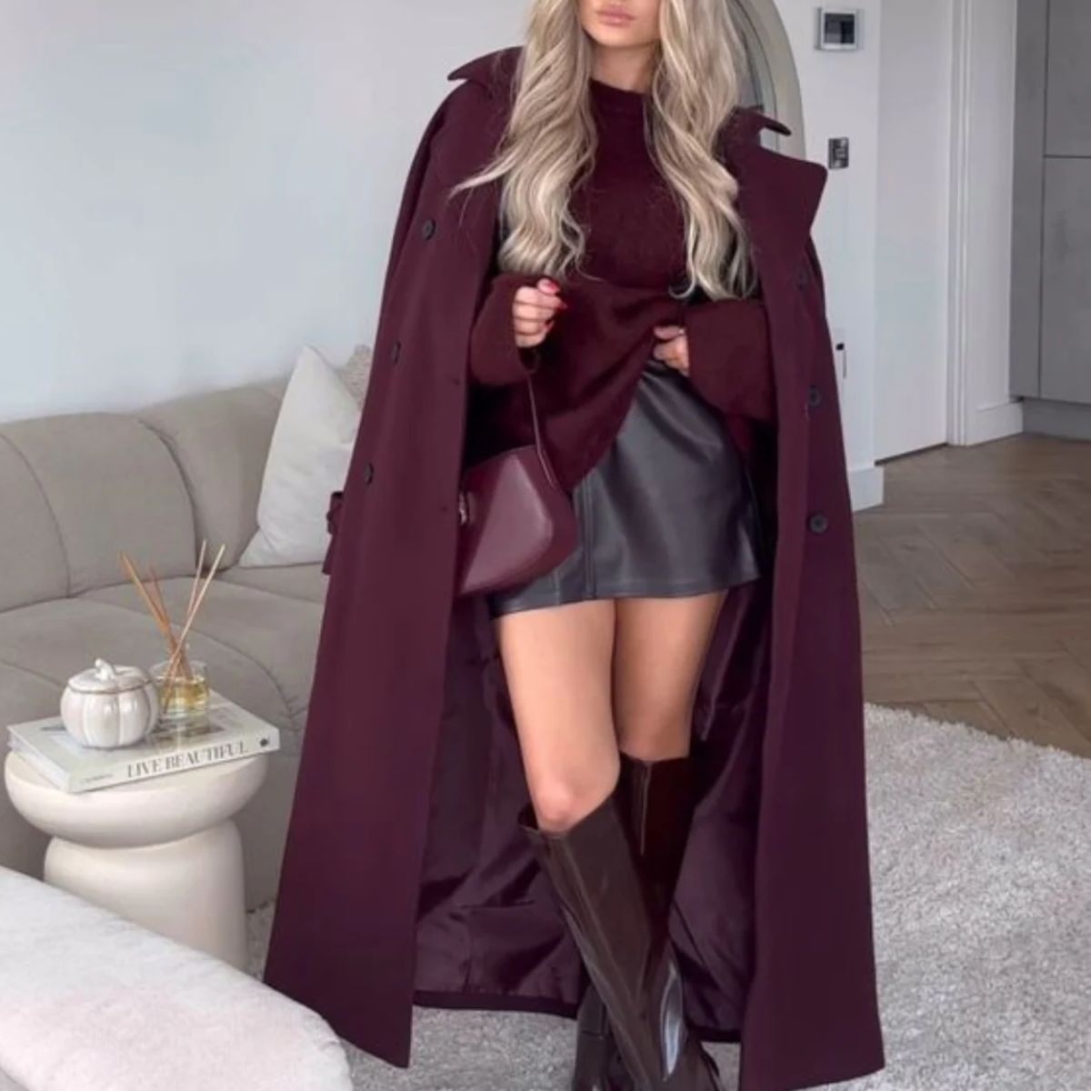 Burgundy belted trench coat with wide lapels and buttoned cuffs