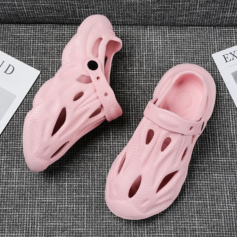 Pink hollow garden clogs with oval cutouts and adjustable strap