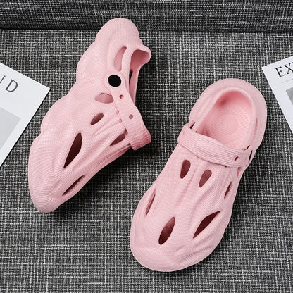 Pink hollow garden clogs with oval cutouts and adjustable strap