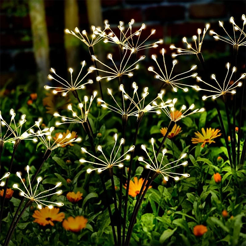 Solar starburst garden lights with warm white LEDs among flowers