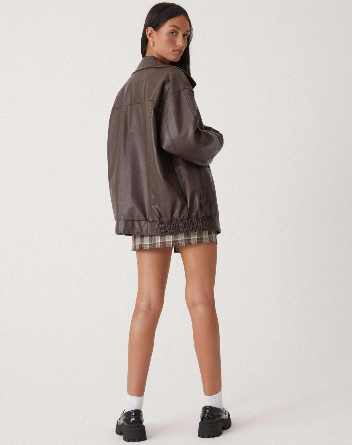 Brown oversized PU leather jacket from side view with zip front and gathered elastic hem.