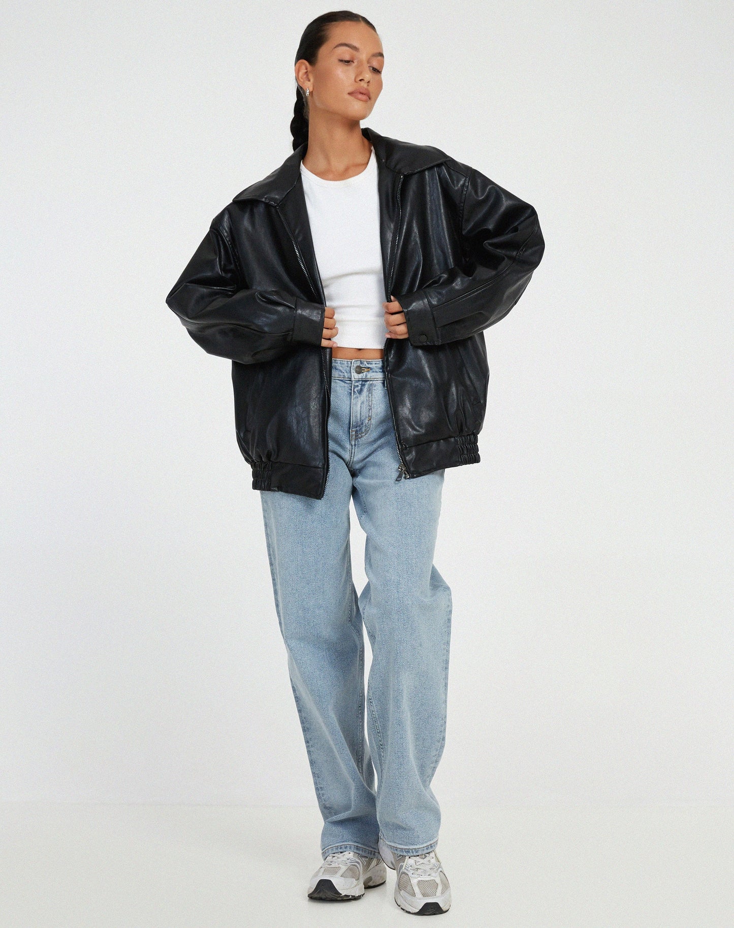 Black oversized PU leather jacket with zip front, stand collar, and elastic cuffs.