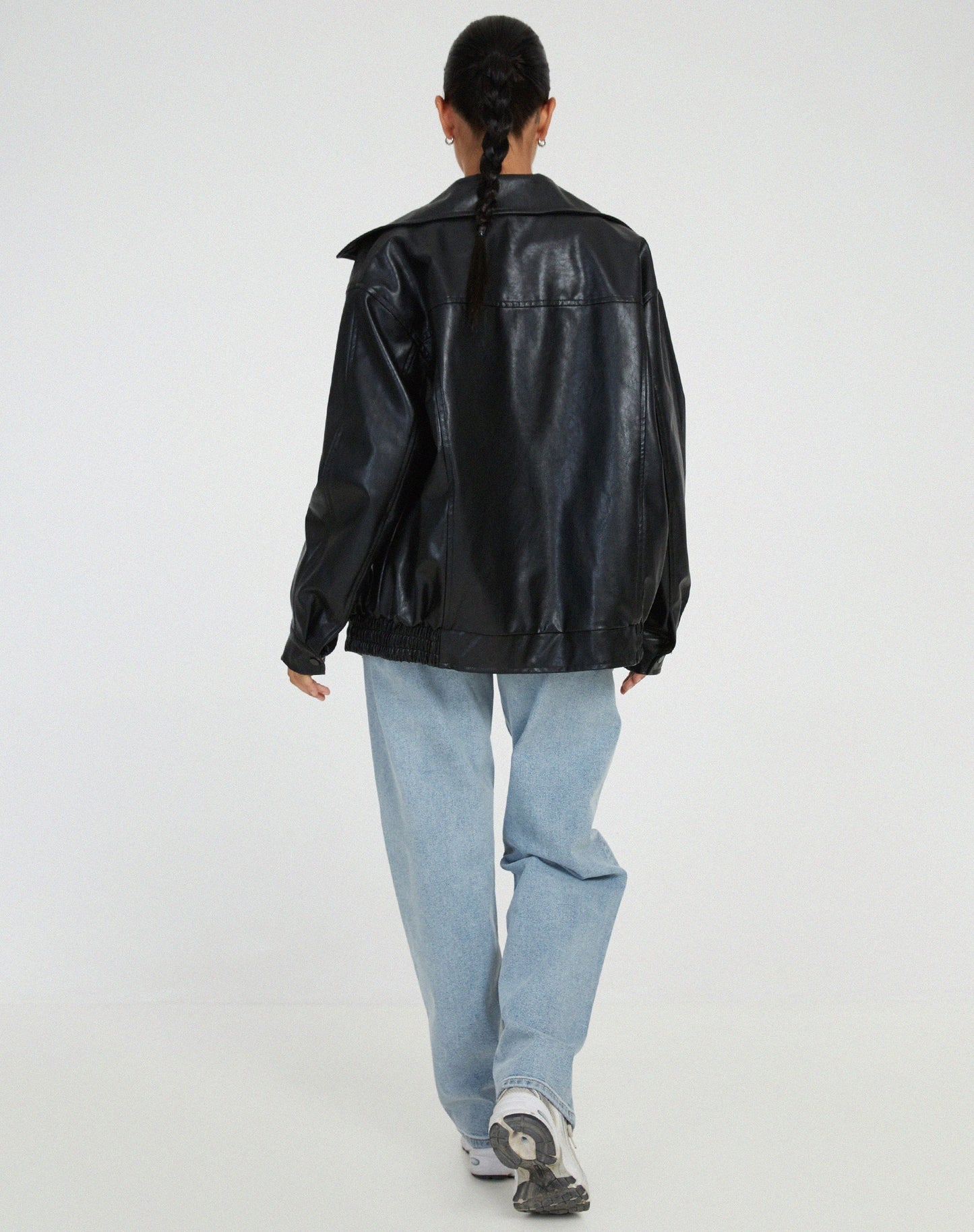 Black oversized PU leather jacket back view with full-length zip and elastic hem.