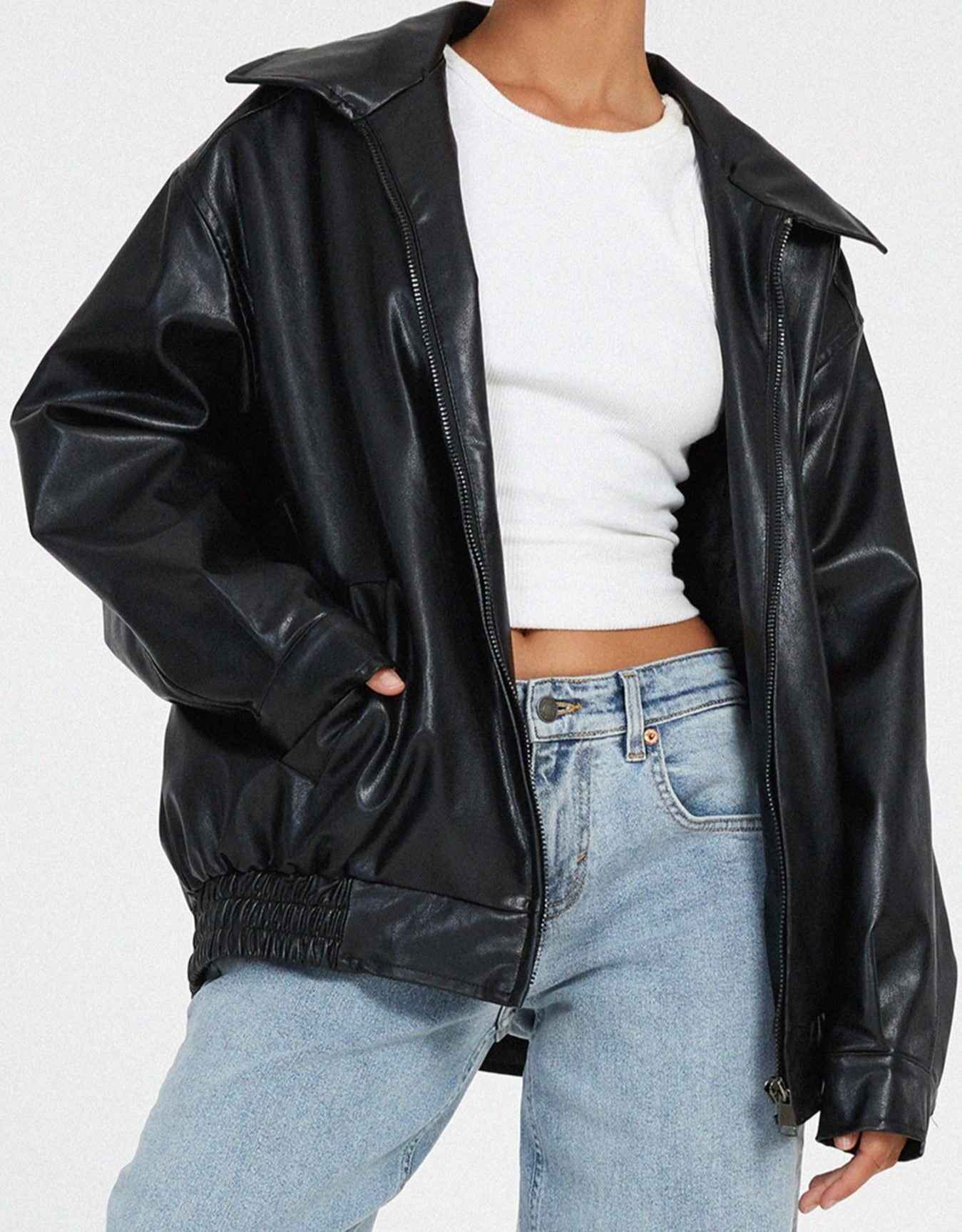 Black oversized PU leather jacket detail with zip front and elastic cuff at sleeve hem.