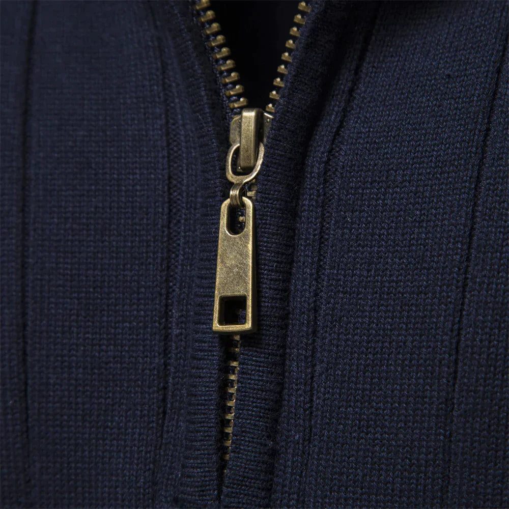 Close-up of navy half-zip knit sweater zipper with gold hardware.