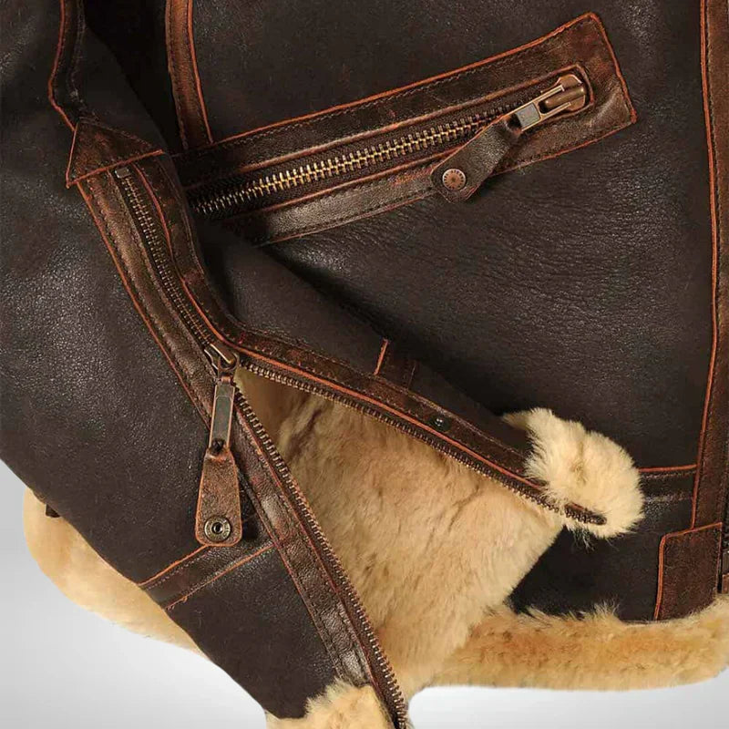 Men's shearling flight jacket sleeve and interior pocket detail with zipper and tan shearling lining