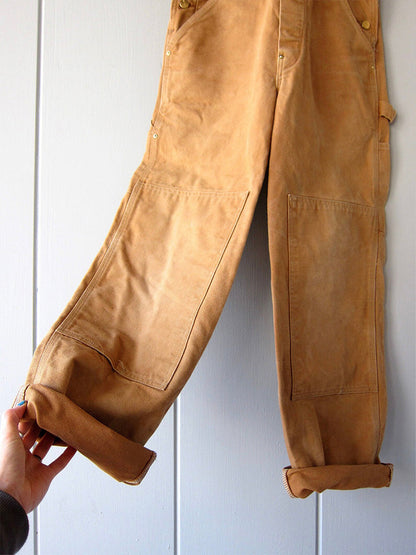 Men's camel canvas overalls close-up with cargo pocket and cuffed leg hem