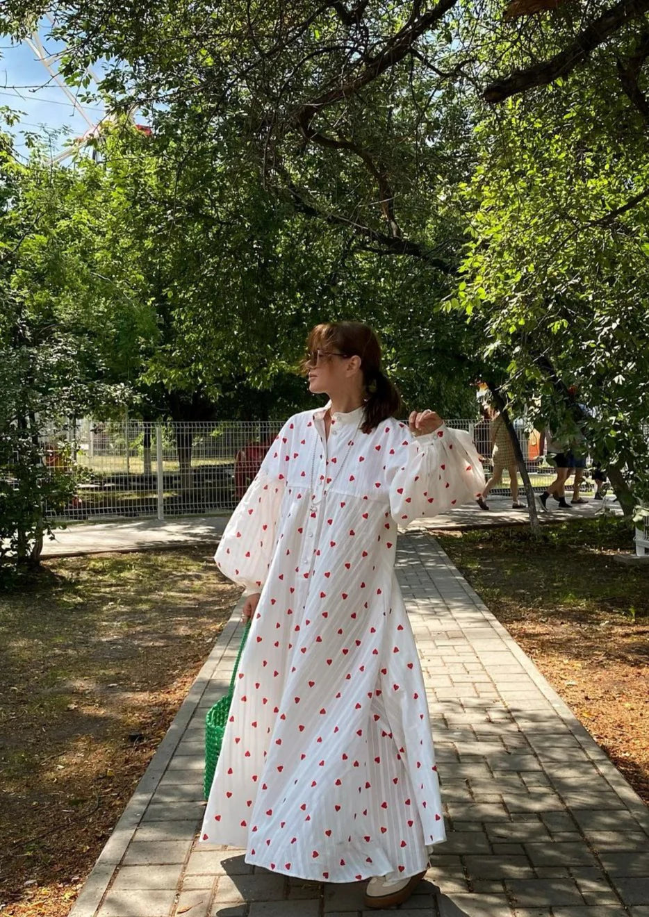 White maxi dress with red heart print, long sleeves, button front, full skirt