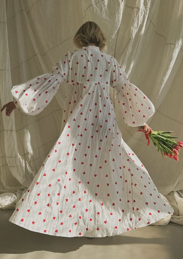 White maxi dress with red heart print, button back, long flared sleeves