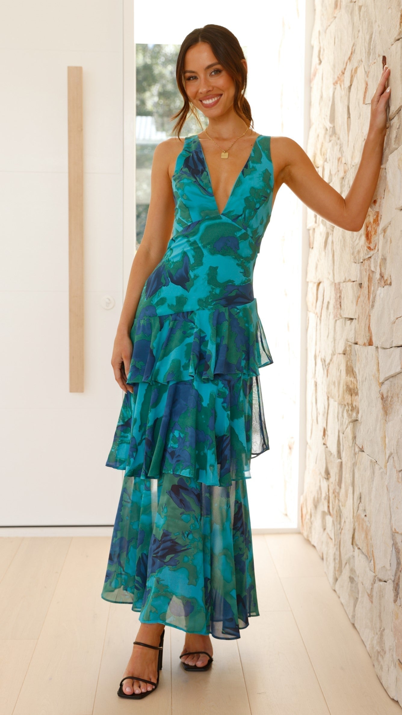 Deep V-neck tiered ruffle maxi dress, teal-blue floral, sleeveless with layered tiers.