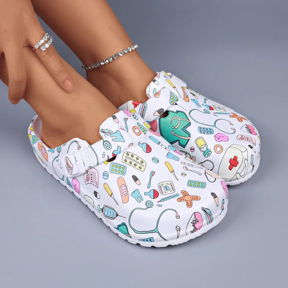 White medical-print nurse clogs with adjustable buckle and textured anti-slip sole.