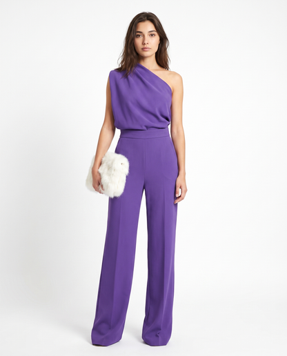 Purple sleeveless belted jumpsuit with one-shoulder drape and wide-leg pants.