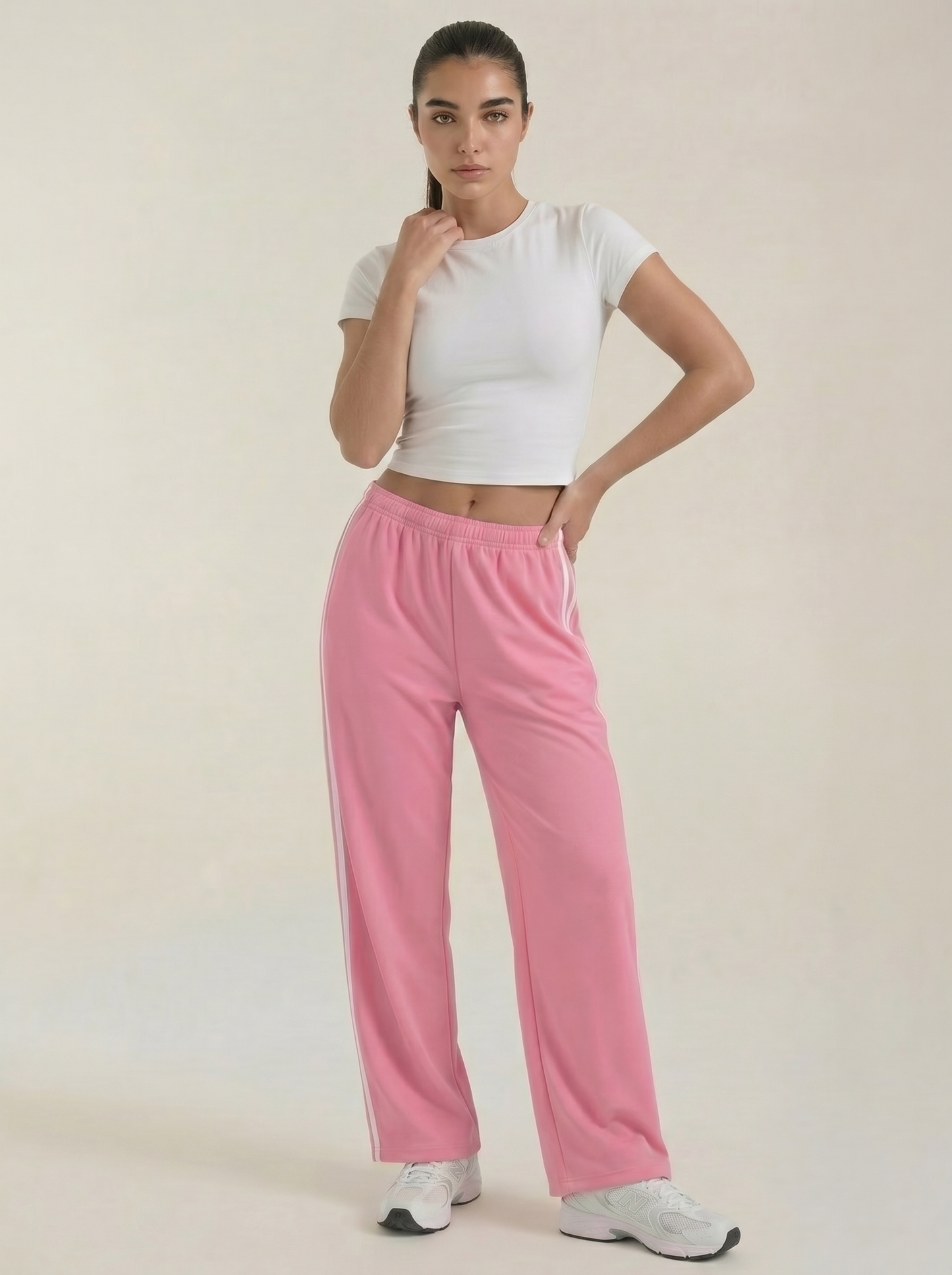 Pink wide-leg track pants with elastic waistband and drawstring, featuring white side stripes