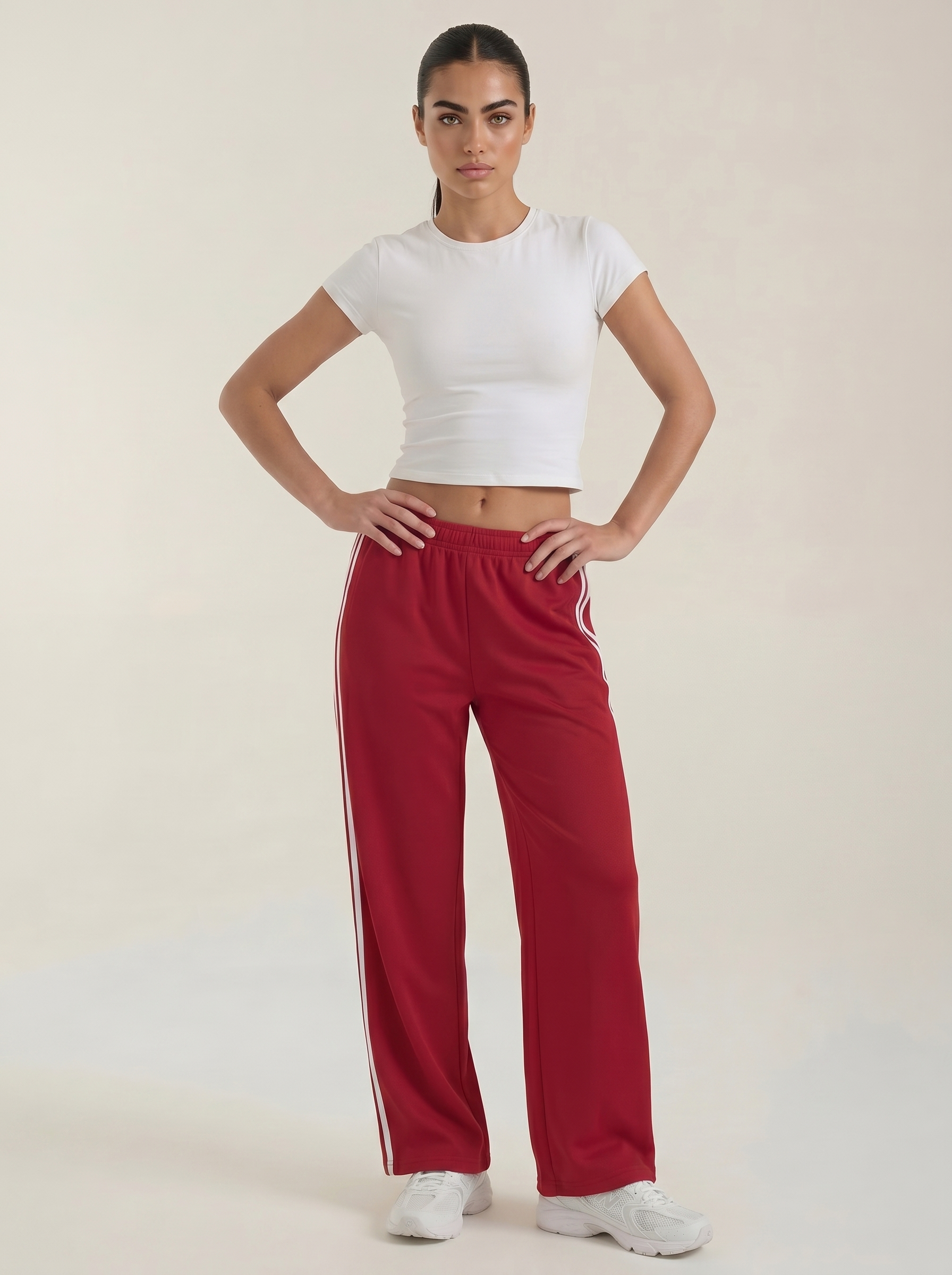 Red wide-leg track pants with elastic waistband, drawstring tie, and white side stripes