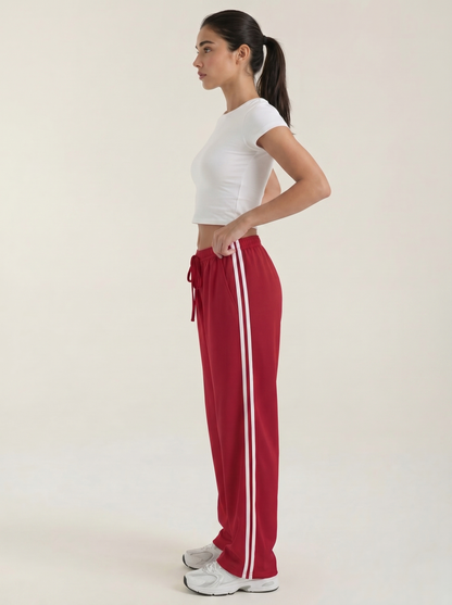 Red wide-leg track pants with drawstring elastic waist and long white side stripe detail
