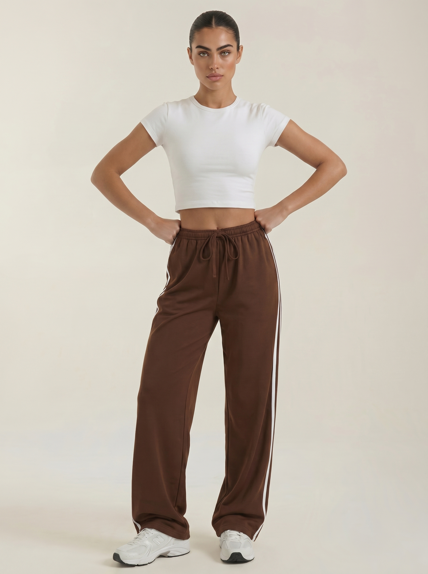 Brown wide-leg track pants with elastic waistband, drawstring tie, and no side stripes