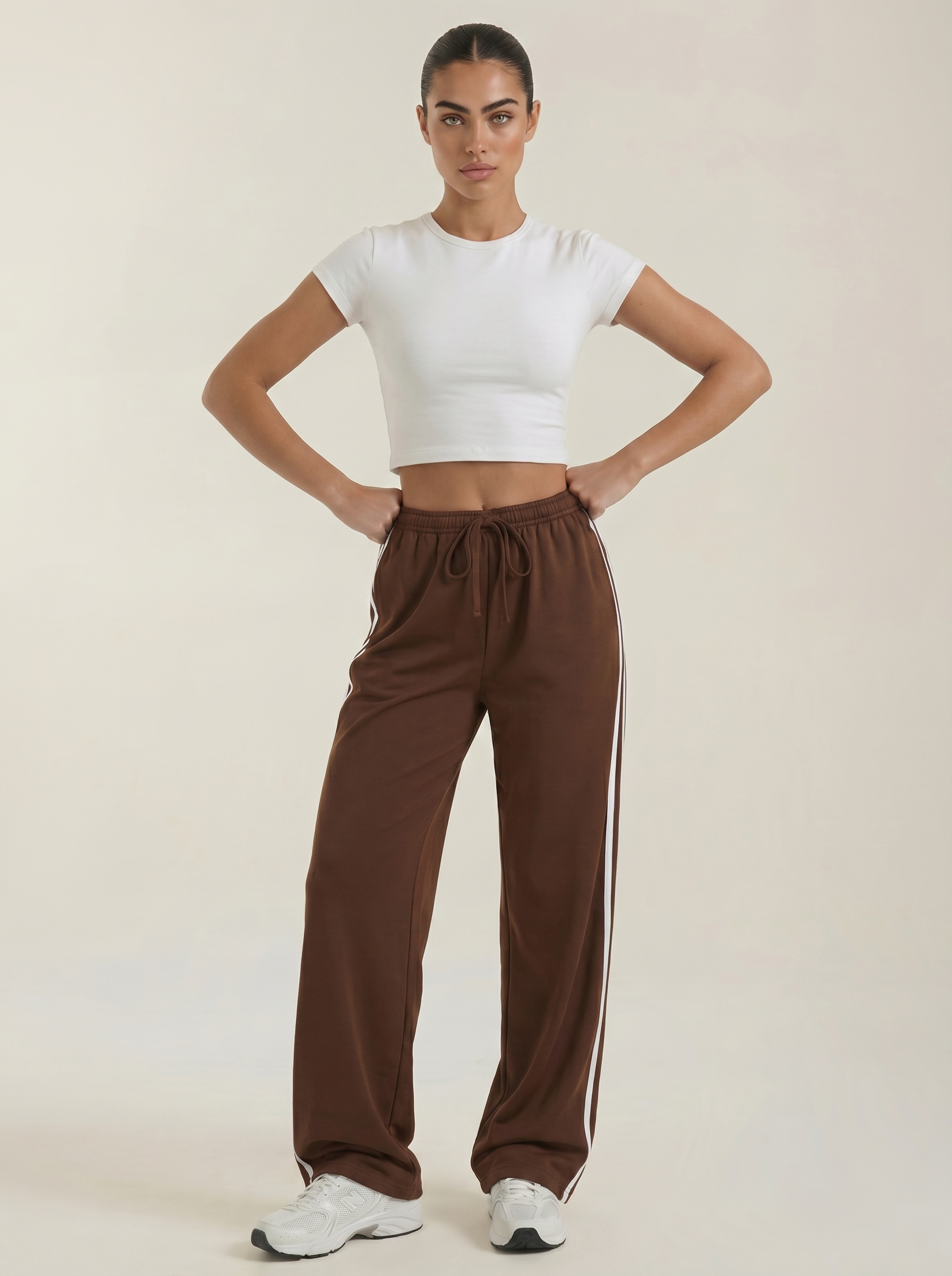 Brown wide-leg track pants with elastic waistband, drawstring tie, and no side stripes