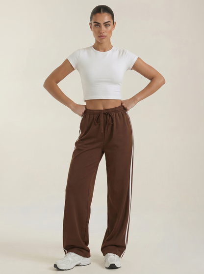 Brown wide-leg track pants with elastic waistband, drawstring tie, and no side stripes