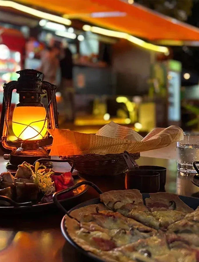 Bronze vintage camping lantern glowing on a tabletop